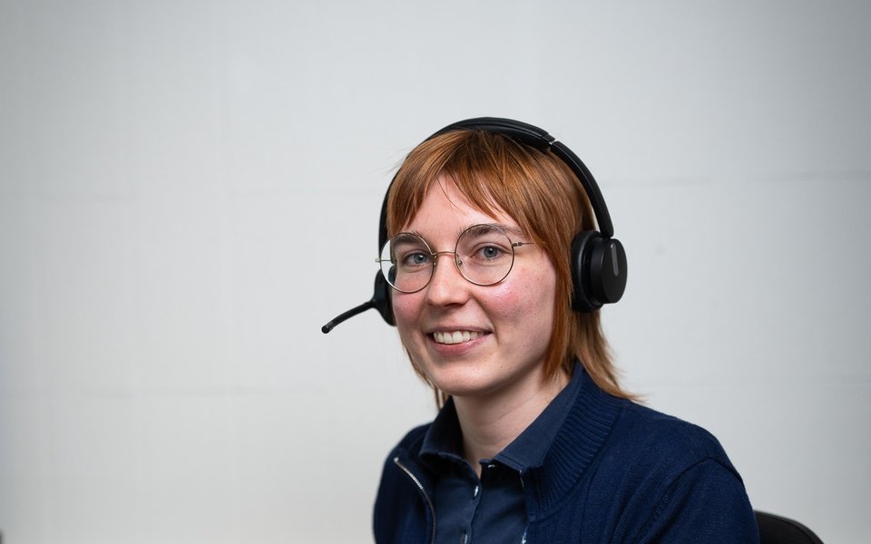 Eine Mitarbeiterin der Knut Apotheke mit Headset am Arbeitsplatz, bereit für Rückfragen von Pflegeteams und Arztpraxen.